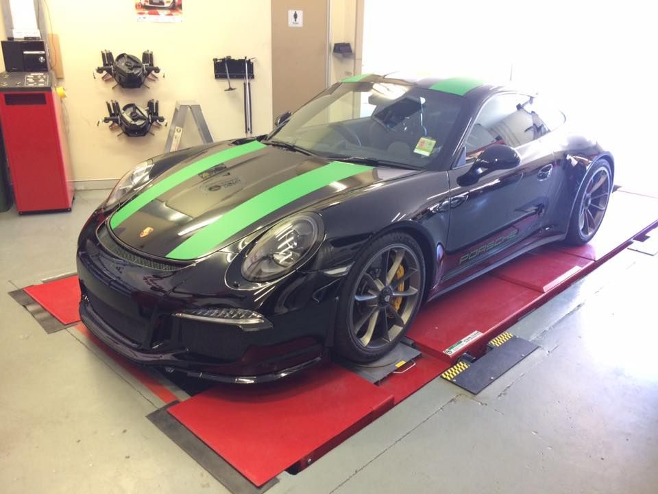 A Black Porsche Is Sitting On A Lift In A Garage — Rallimax Wheel Repairs & Alignments in Cootamundra, NSW