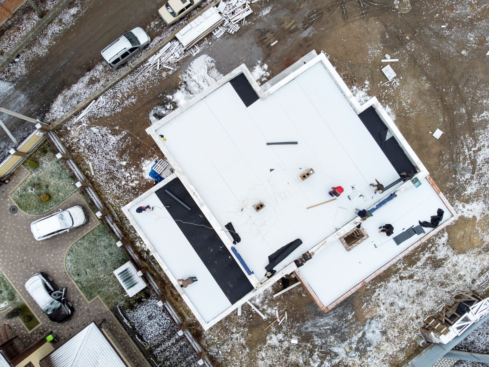 An aerial view of a building under construction in the snow.