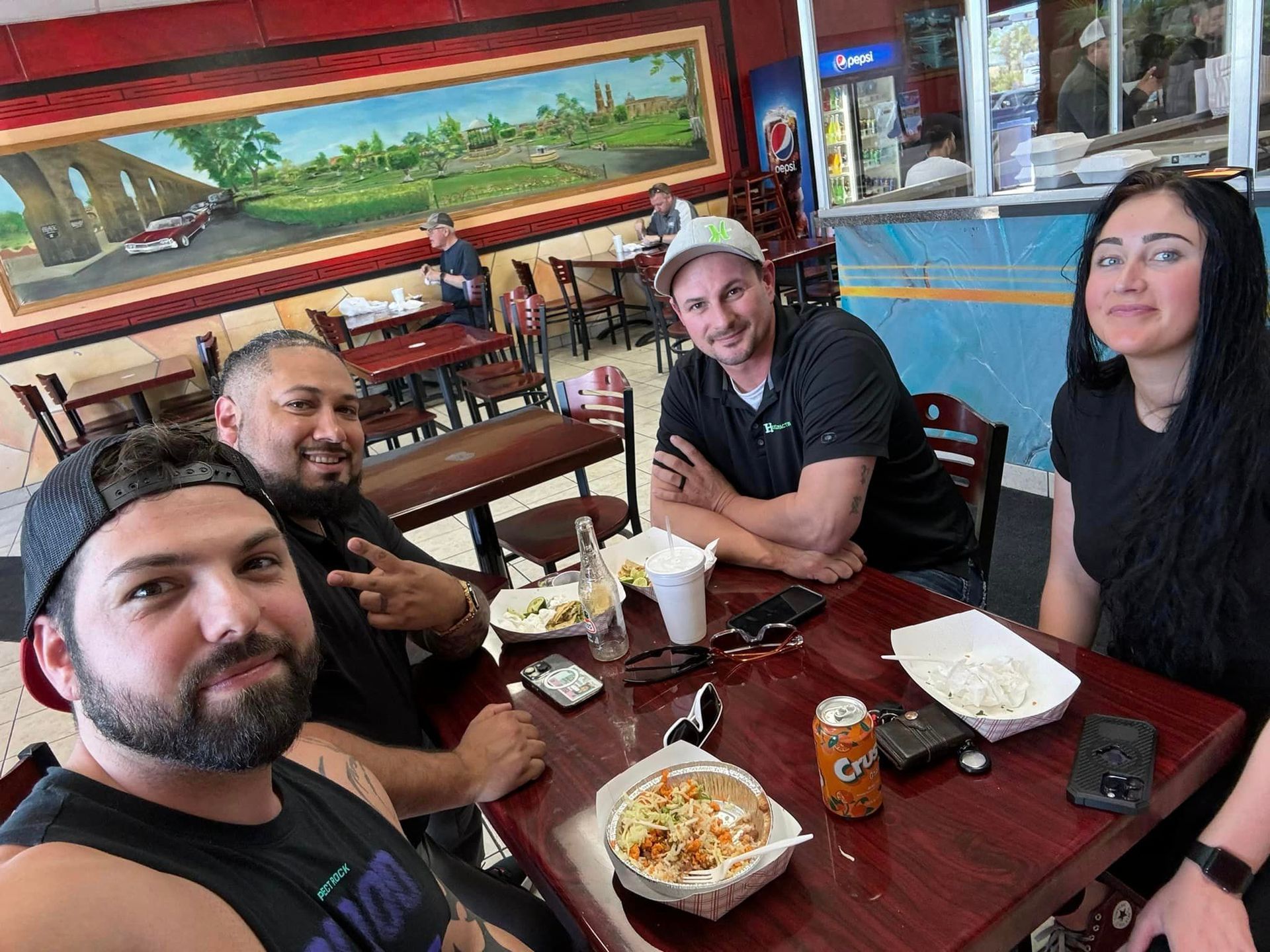 A group of people are sitting at a table in a restaurant.