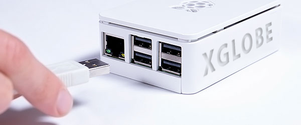 A person is plugging a usb cable into a xglobe box.