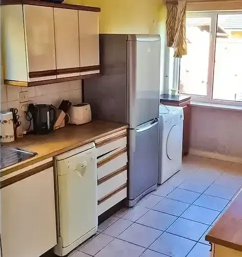 A kitchen with a refrigerator , dishwasher , and washing machine.