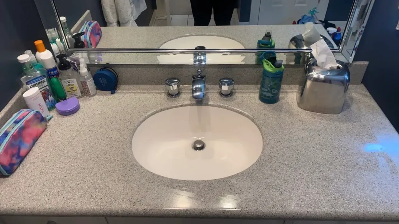 A bathroom sink with two sinks and a mirror.