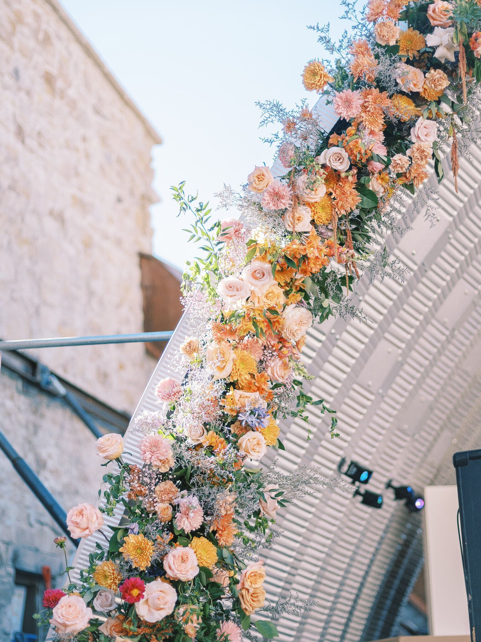 A bunch of flowers are hanging from the ceiling of a building.