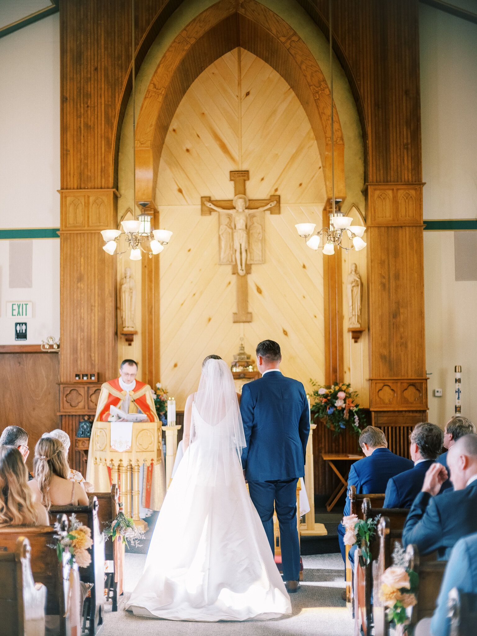 A bride and groom are walking down the aisle of a church during their wedding ceremony.