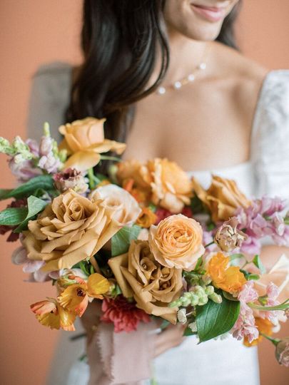 A woman in a white dress is holding a bouquet of flowers.