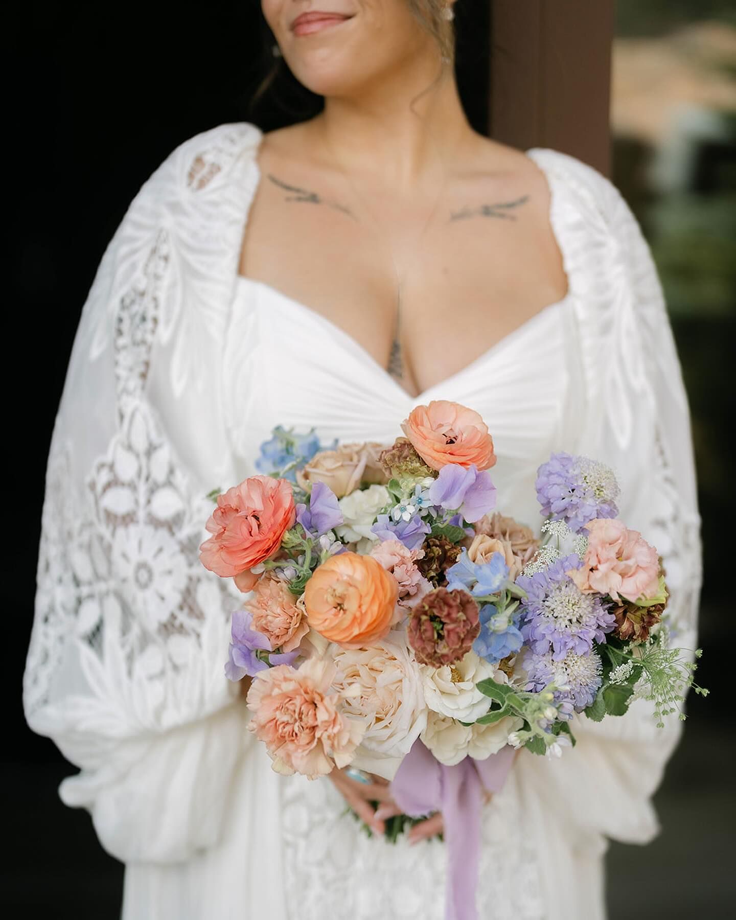 A woman in a white dress is holding a bouquet of flowers.
