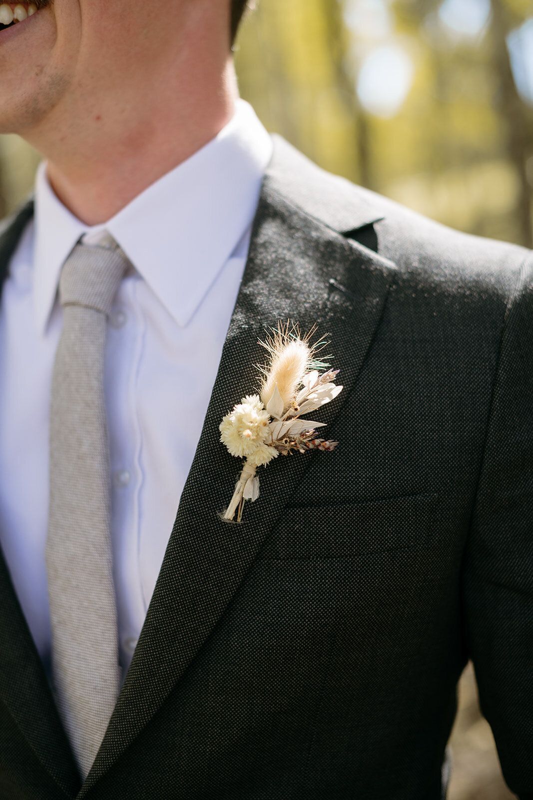 A man in a suit and tie has a flower in his pocket.