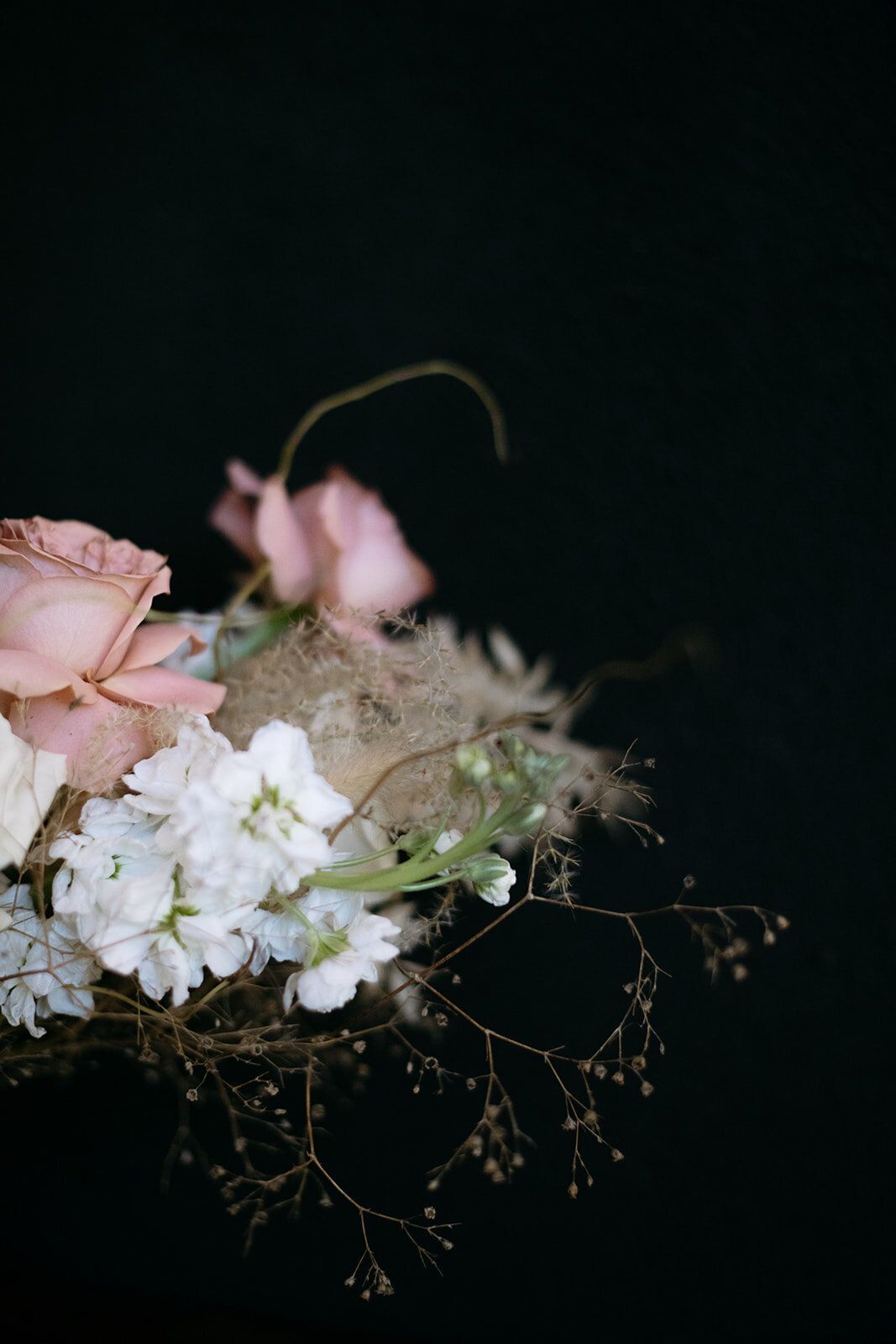 A close up of a bouquet of flowers on a black background.