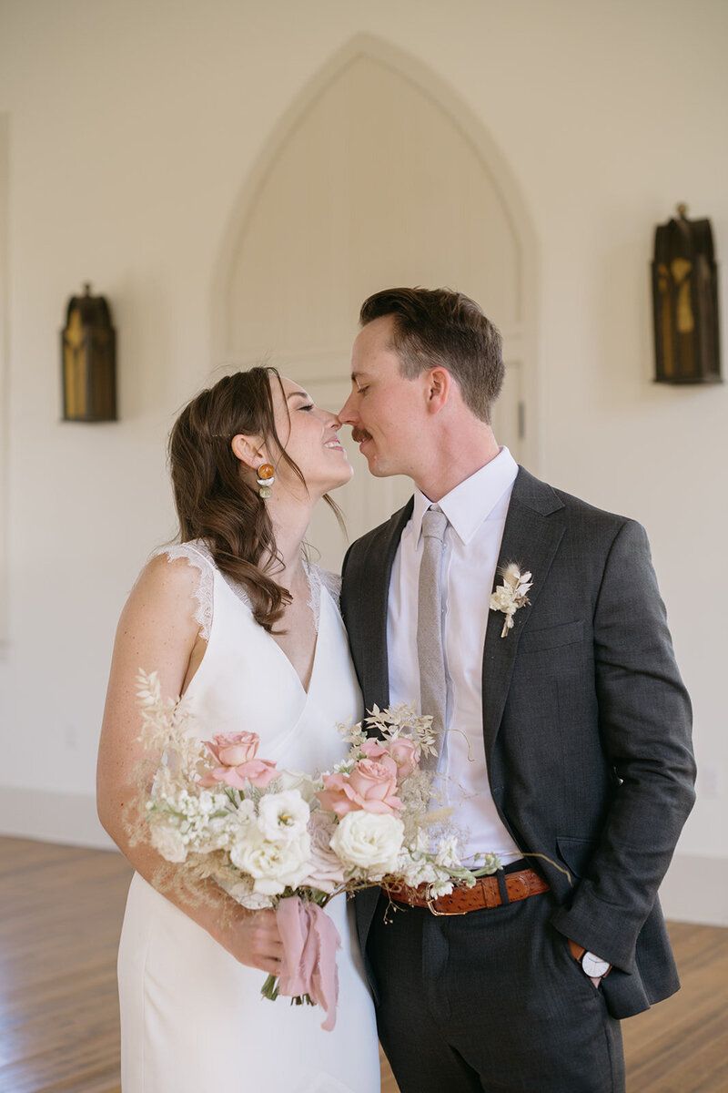 A bride and groom are kissing in a church.