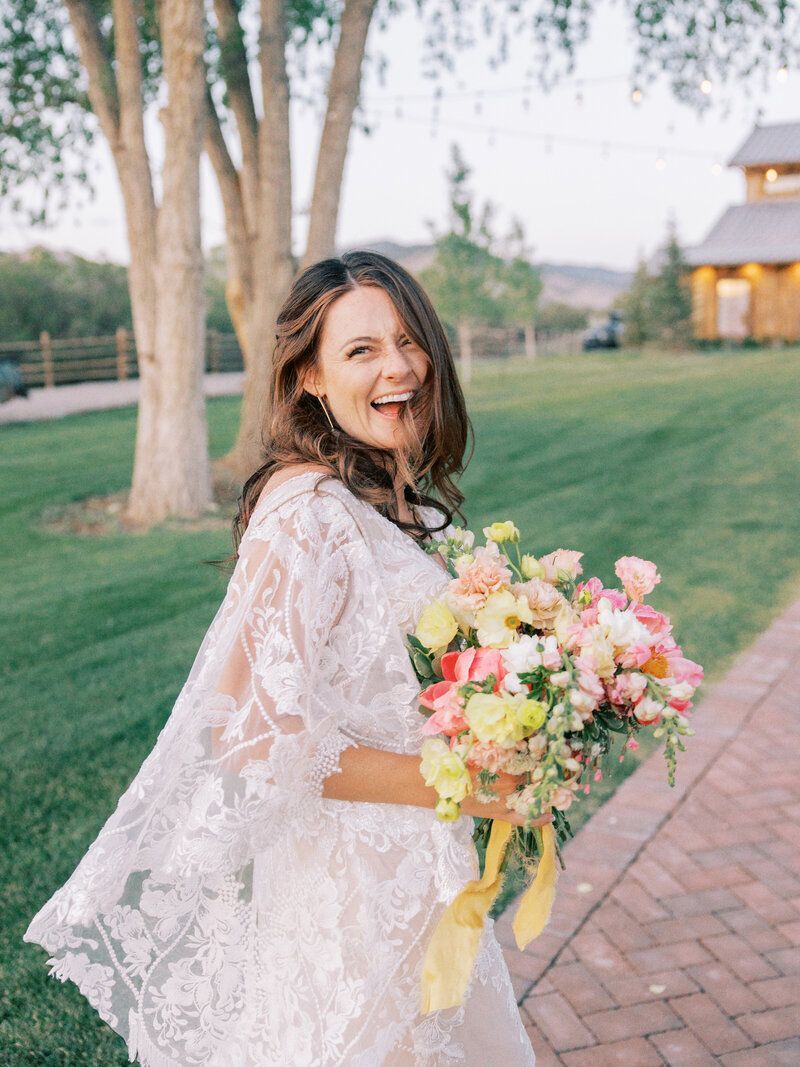 The bride is wearing a white lace dress and holding a bouquet of flowers.