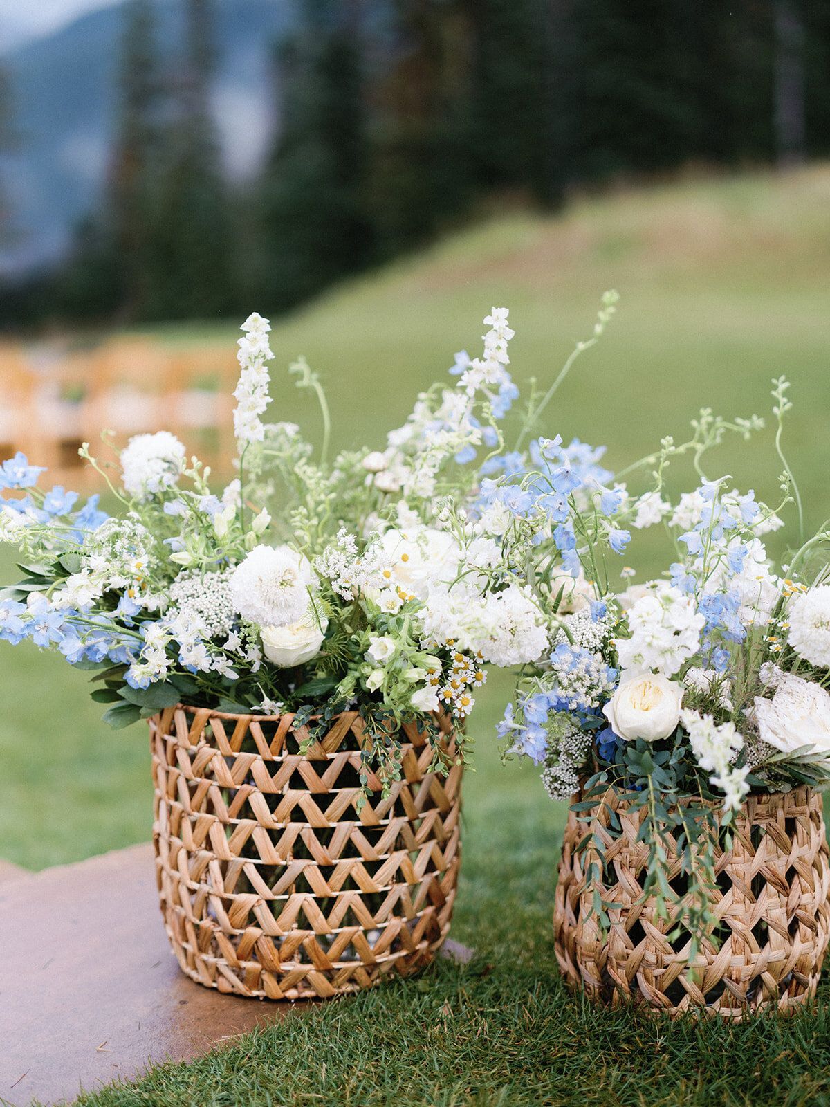 Two baskets filled with white and blue flowers are sitting on a table.