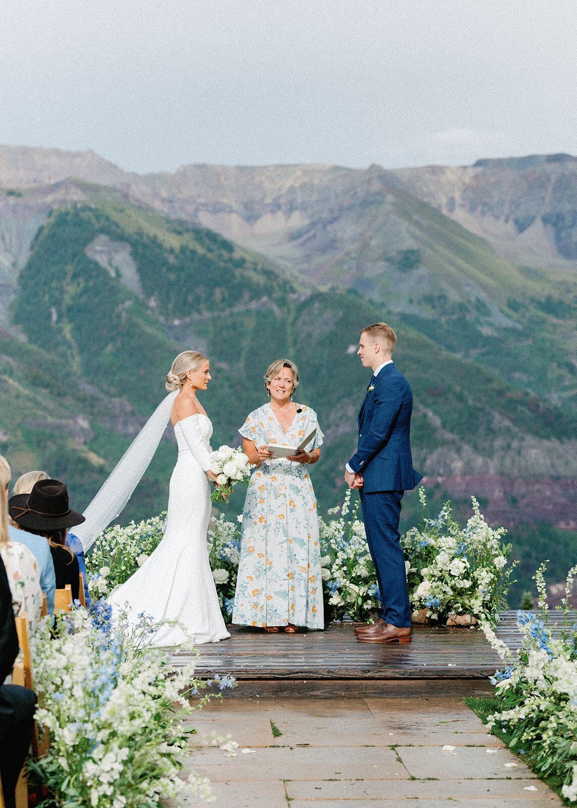 A bride and groom are getting married in front of a mountain range.