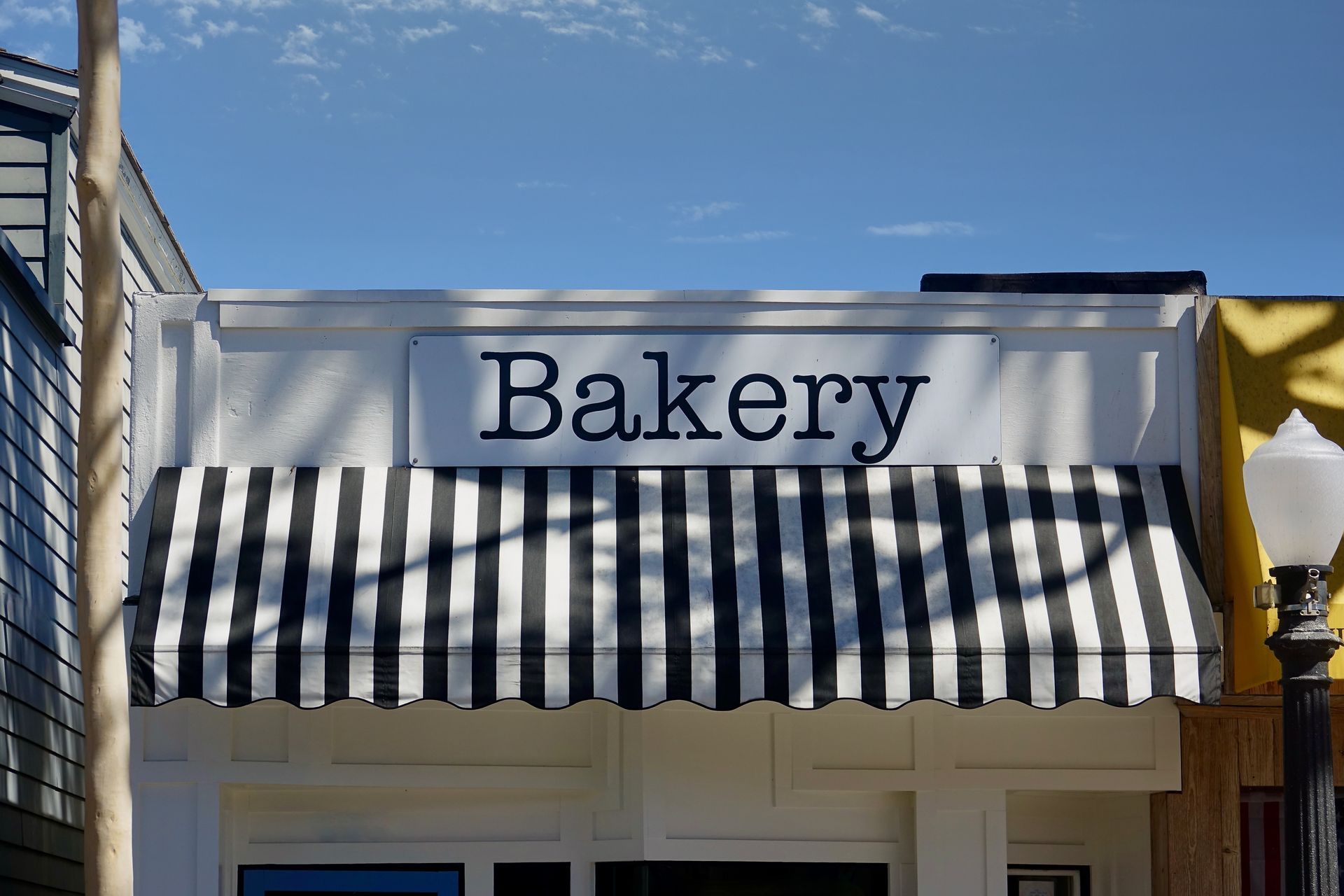 Storefront view featuring a striped awning and bold business sign.
