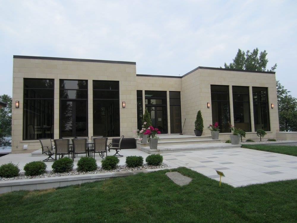 Une grande maison avec beaucoup de fenêtres et un patio