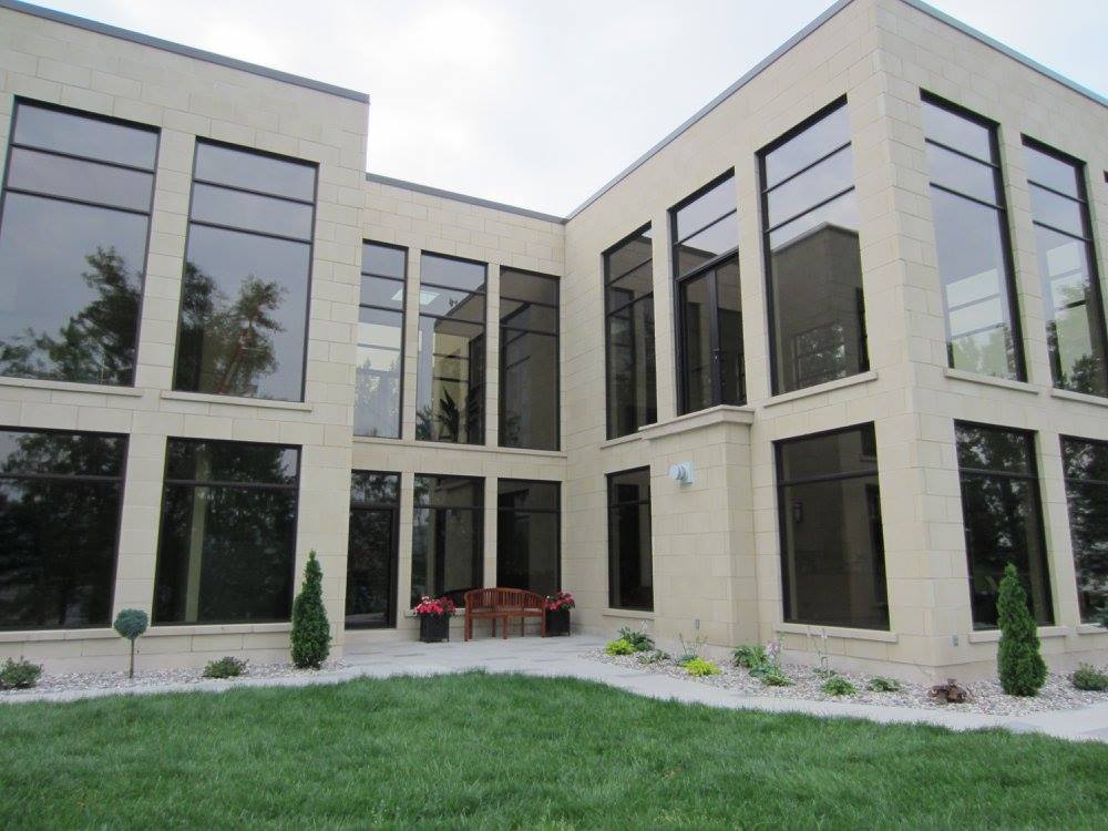 Un grand bâtiment avec beaucoup de fenêtres et une pelouse devant