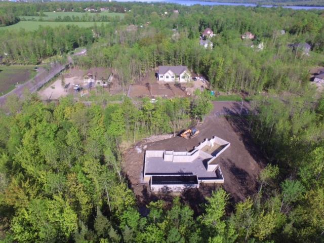 Une vue aérienne d'une maison en construction au milieu d'une forêt.