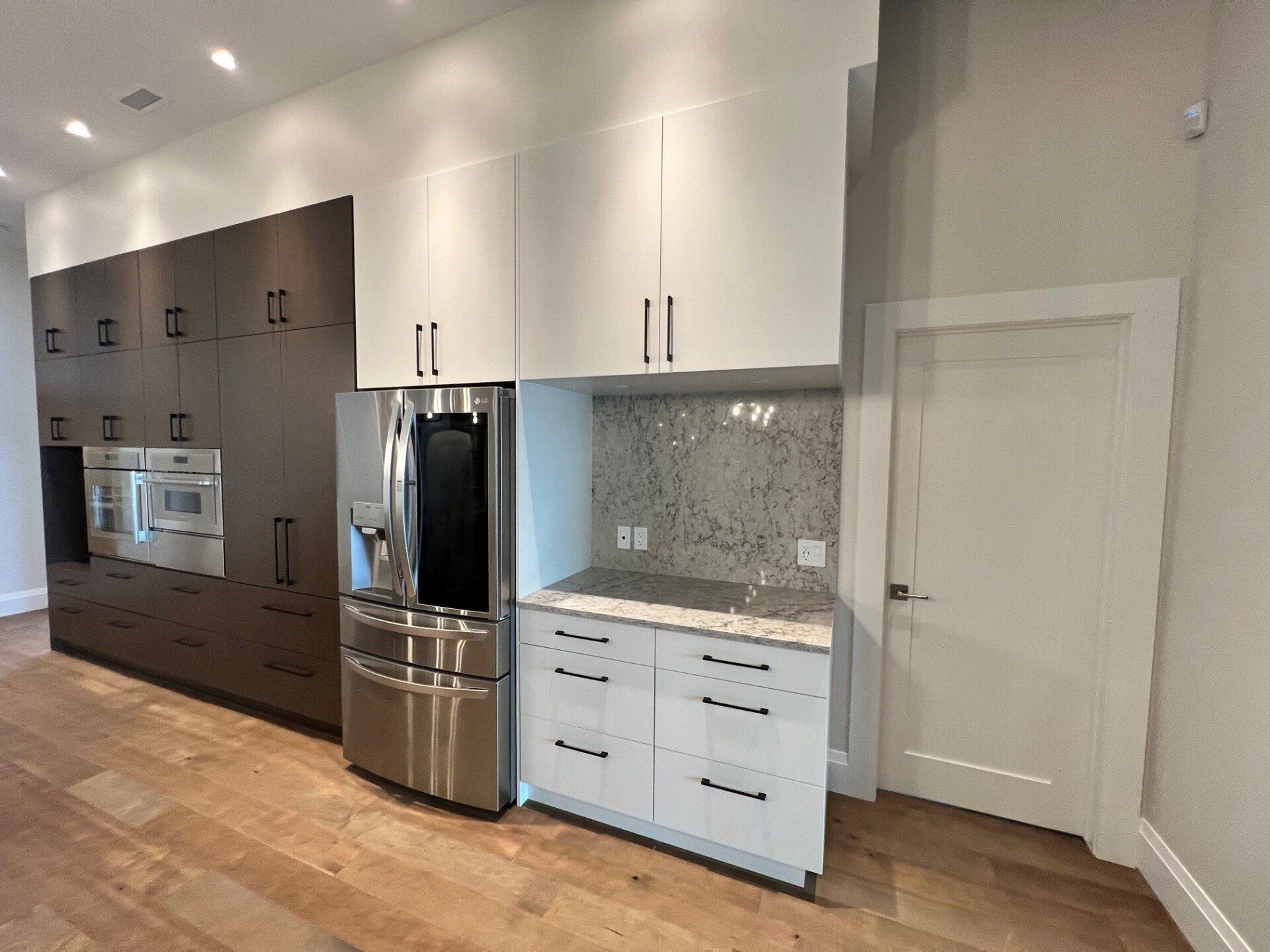 Une cuisine avec des appareils électroménagers en acier inoxydable et des armoires blanches