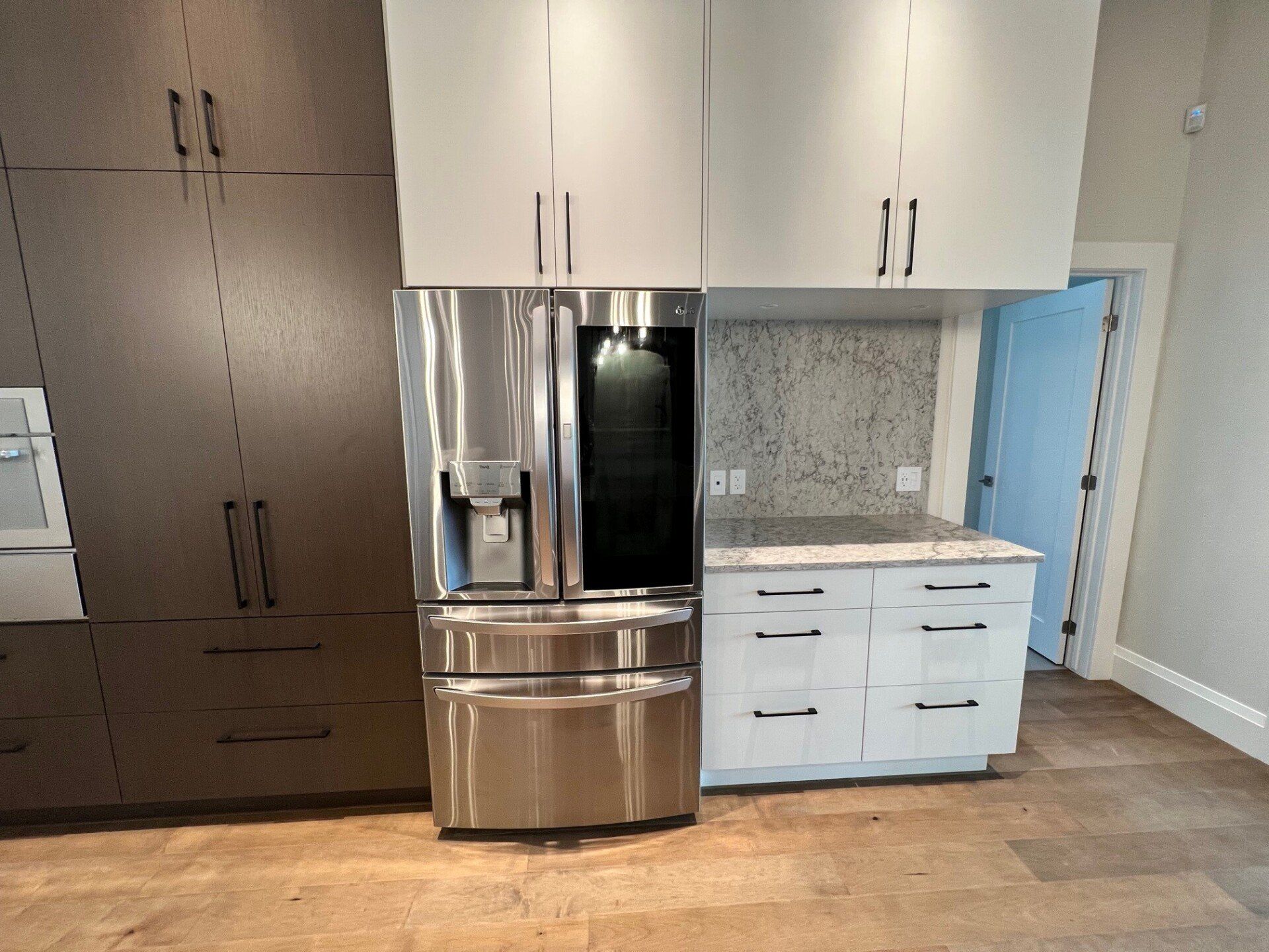 Une cuisine avec des appareils électroménagers en acier inoxydable et des armoires blanches.