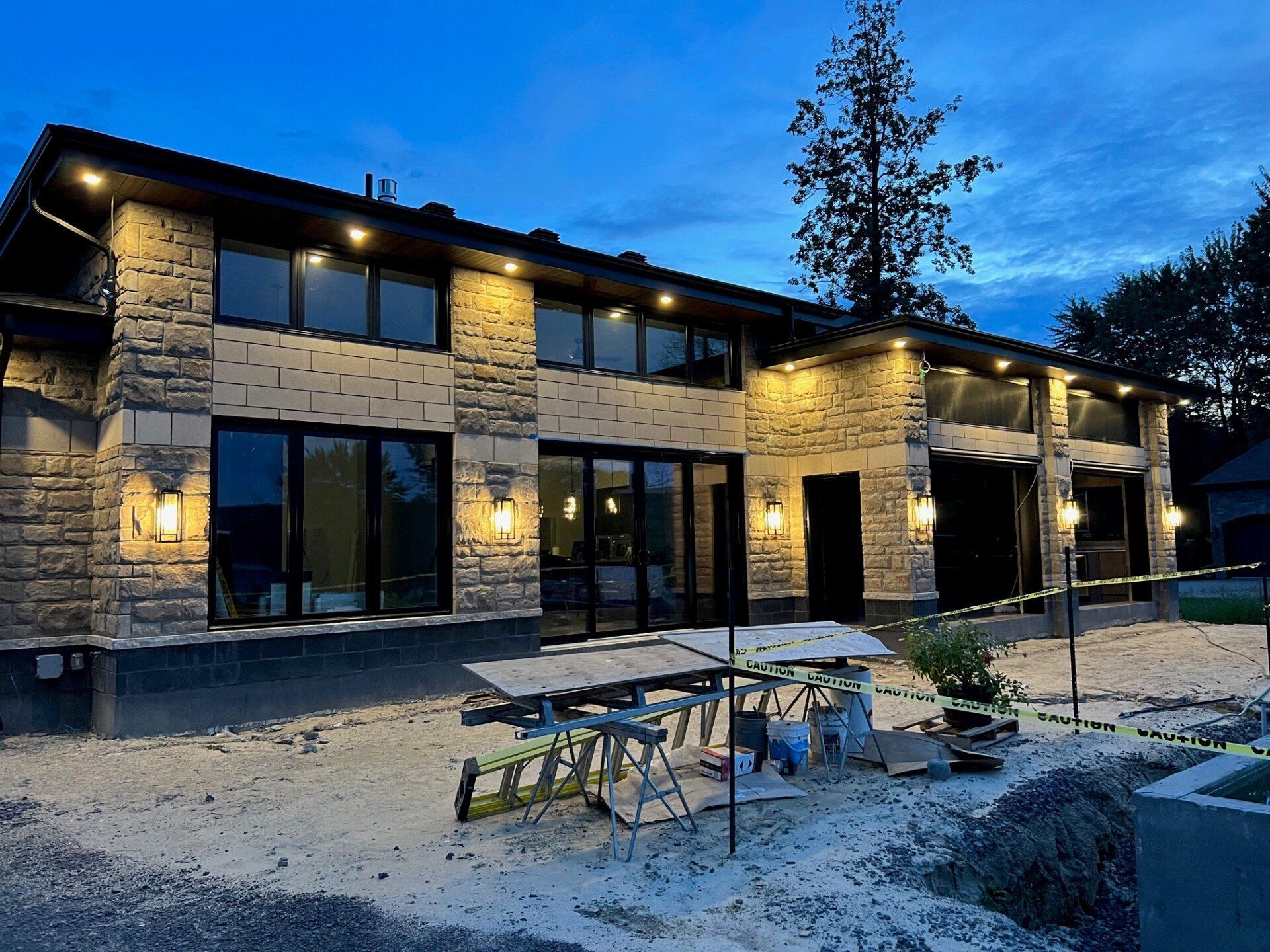 Une grande maison avec beaucoup de fenêtres et une table de pique-nique devant.