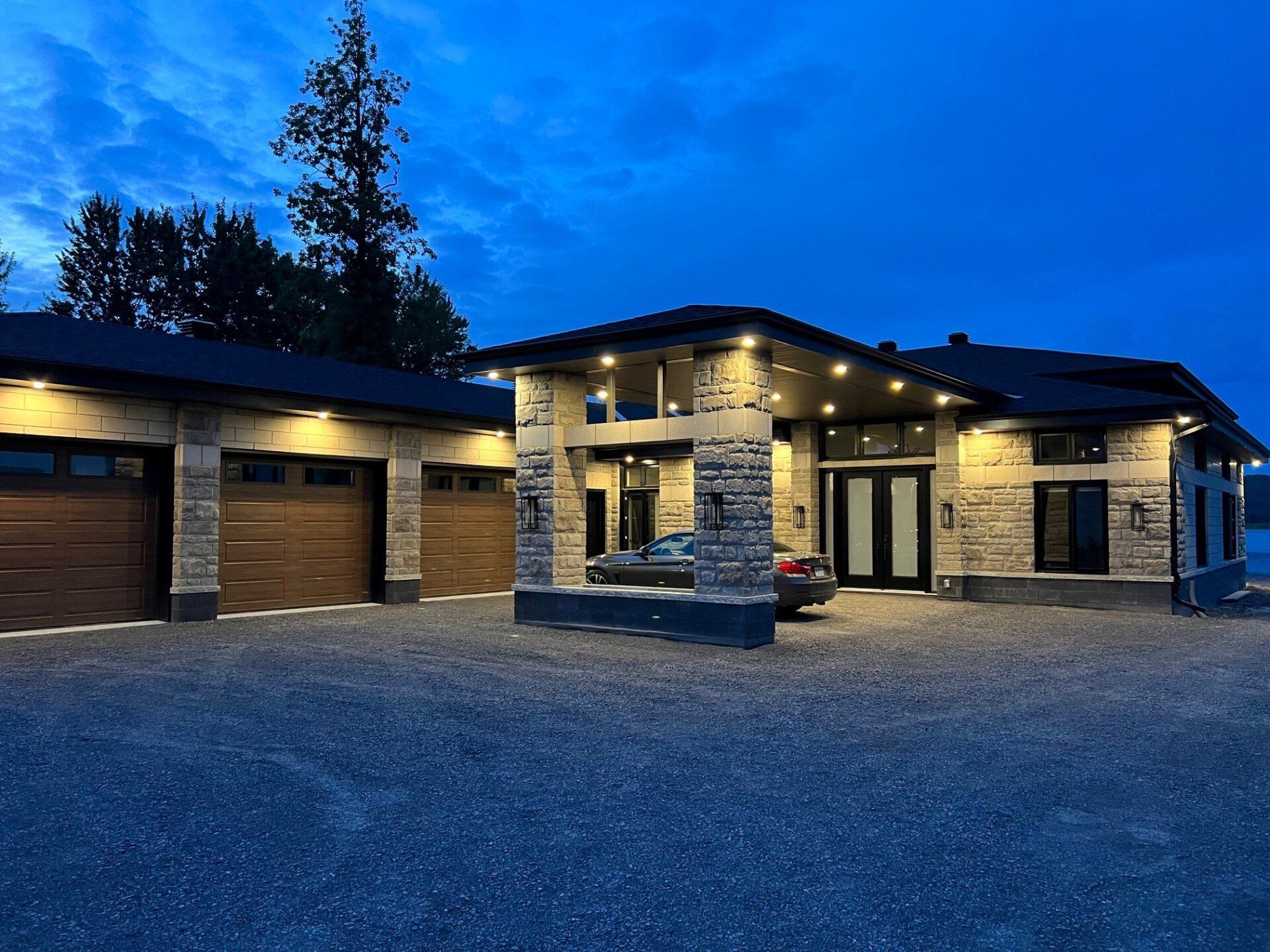 Une maison avec une voiture garée devant elle la nuit