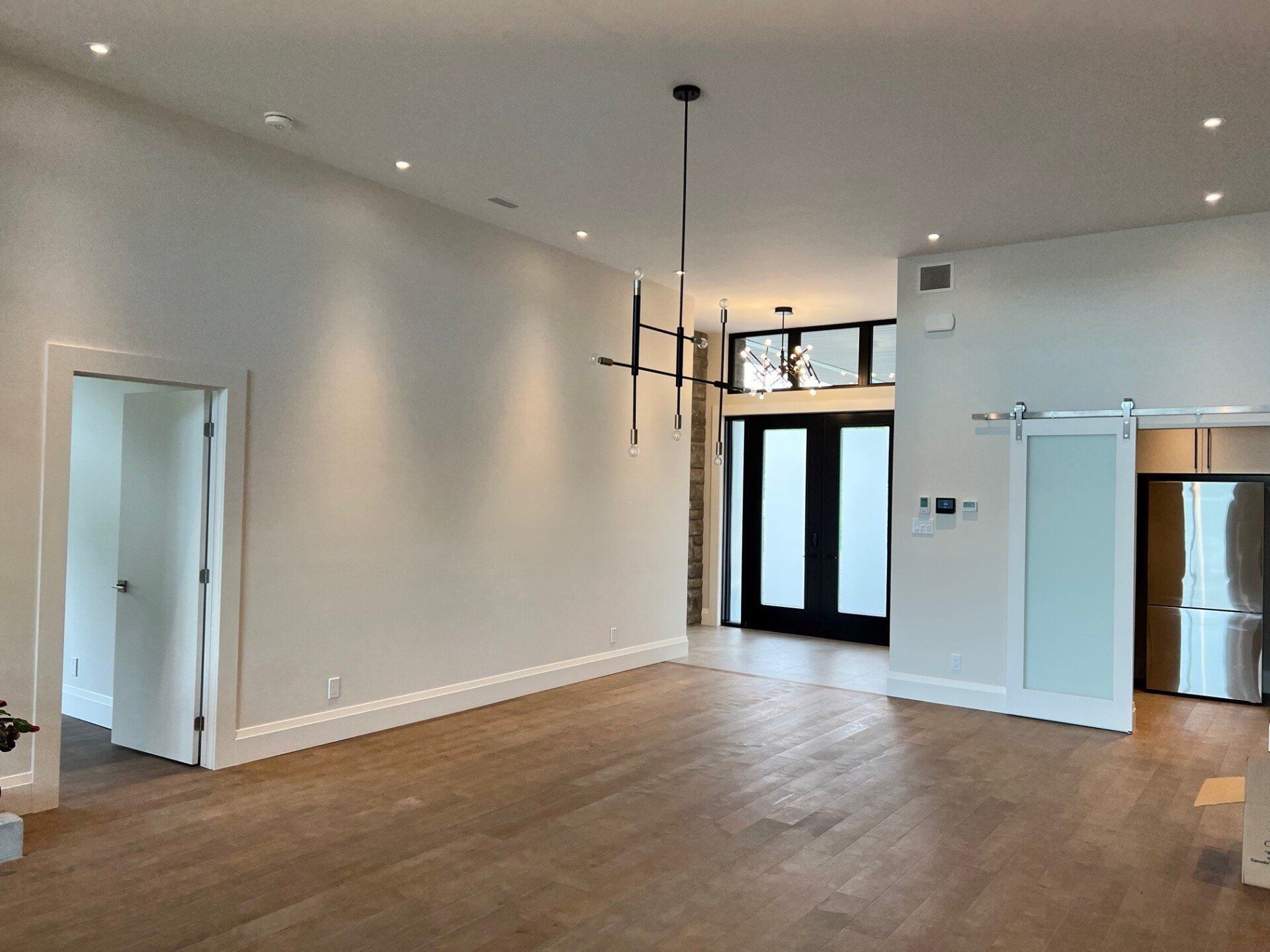 Un salon vide avec du parquet et des murs blancs