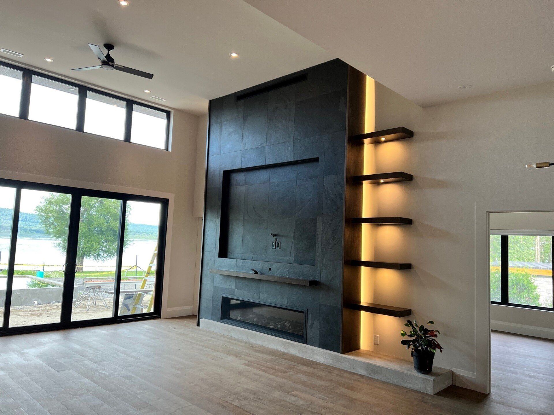 Un salon avec une cheminée et des étagères.