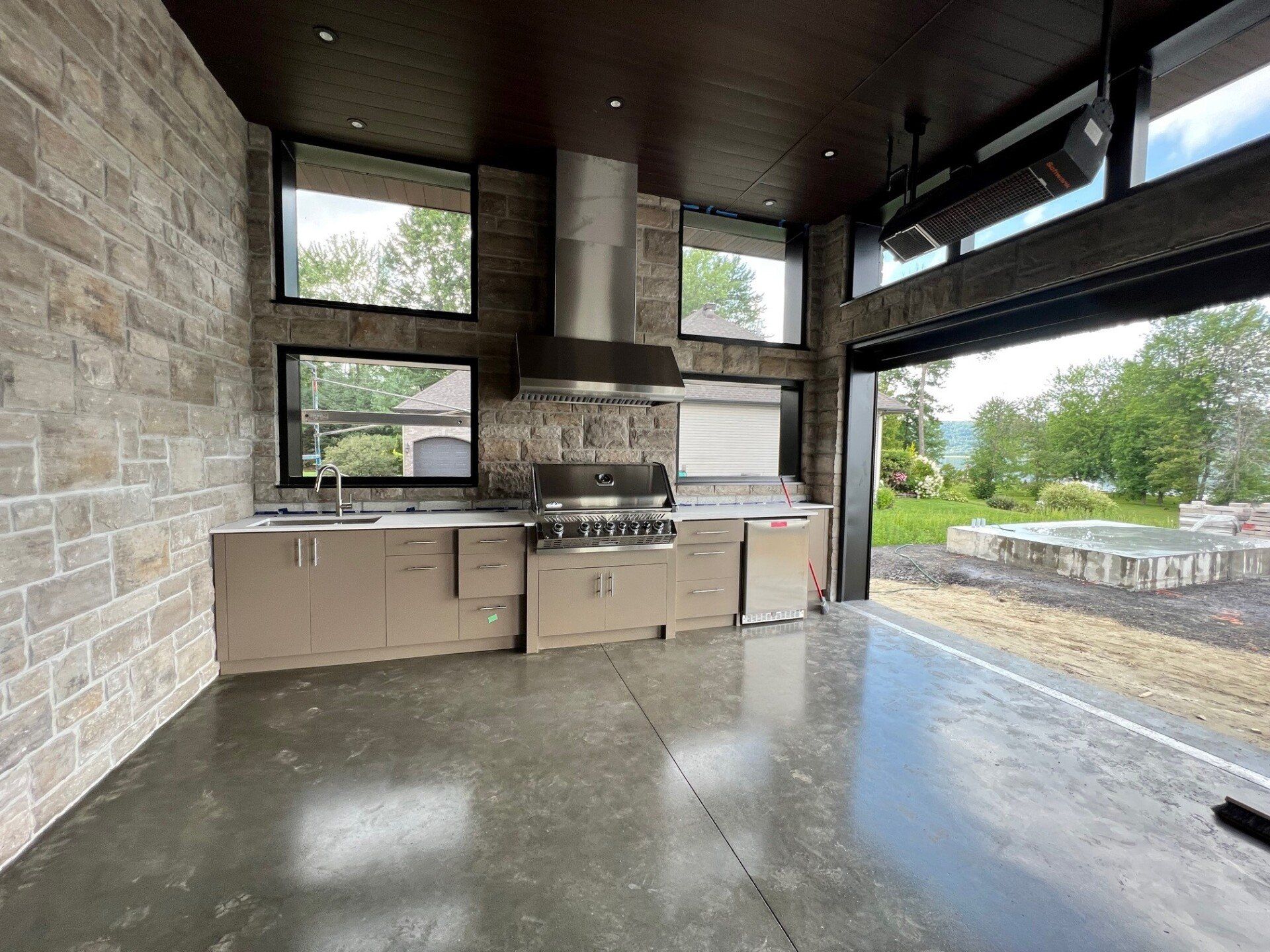 Une cuisine avec électroménagers en acier inoxydable et une grande fenêtre.