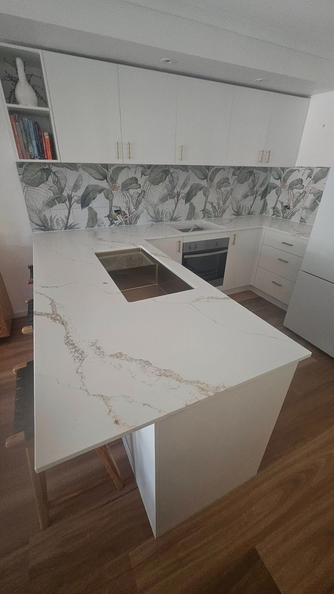 Modern kitchen with white countertops, a built-in cooktop, and patterned backsplash — Sunny Tiling Co in Mount Coolum, QLD