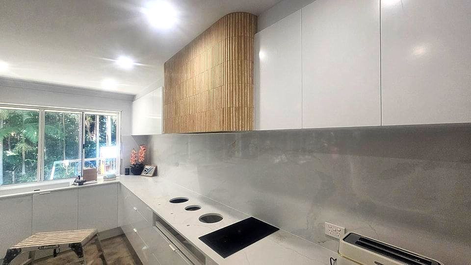 Modern Kitchen With White Cabinets and a Wooden Accent — Sunny Tiling Co in Mount Coolum, QLD