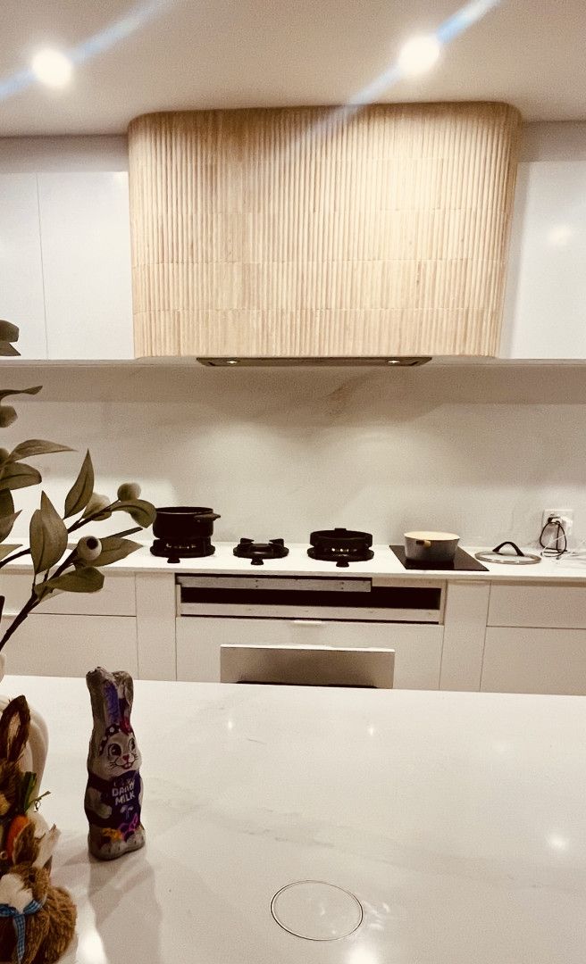 A Kitchen With Brown Cabinets and Stainless Steel Appliances — Sunny Tiling Co in Mount Coolum, QLD