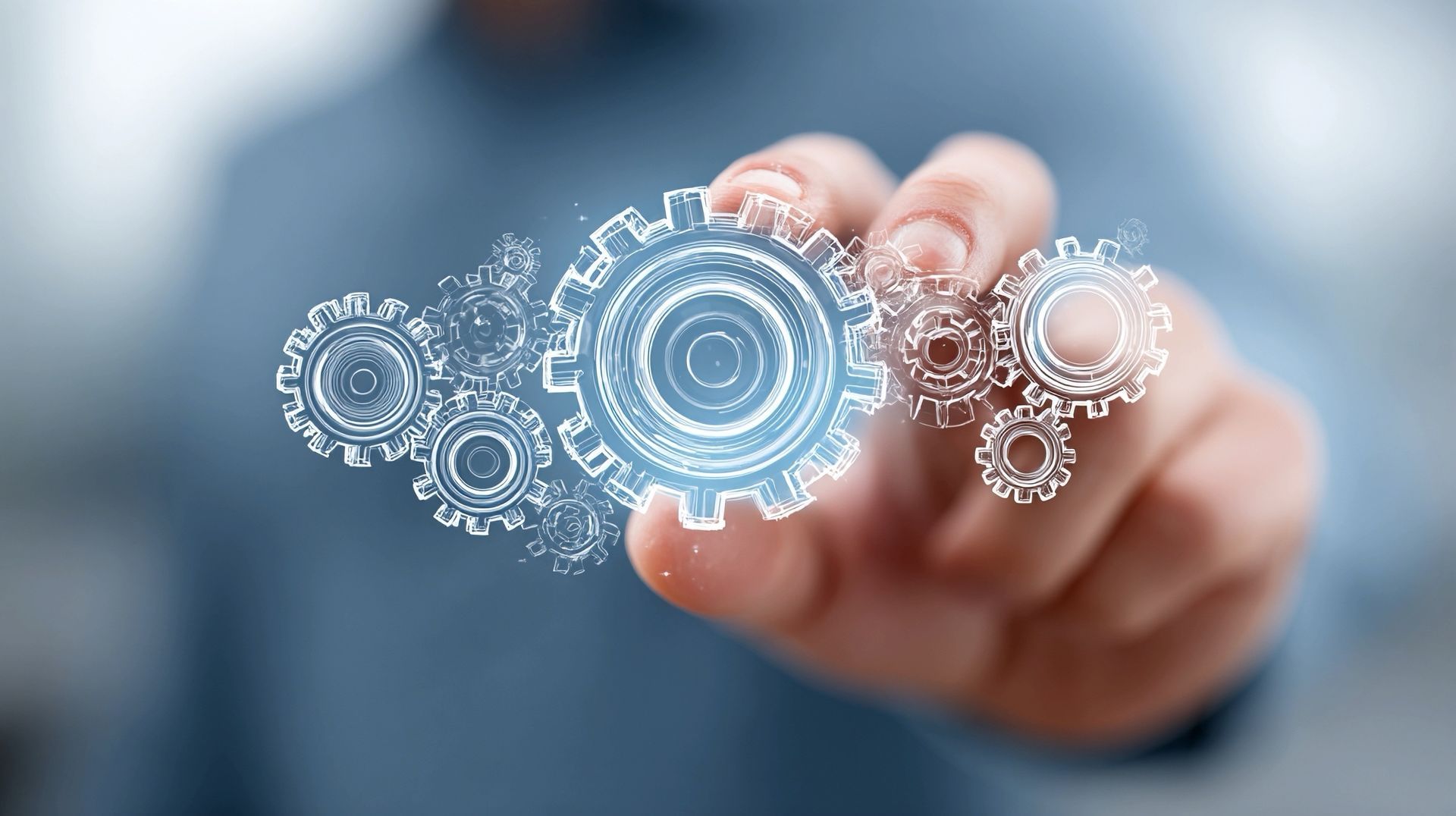 Person's hand touching a cluster of glowing, digital gears, symbolizing technology or processes.