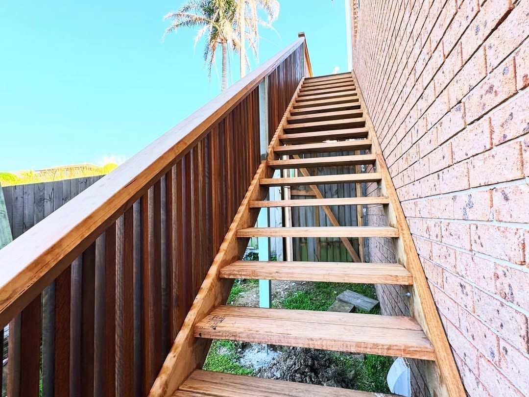 A Wooden Outdoor Staircase with Railing and Brick Wall — Coastline Building & Renovations In Forster, NSW