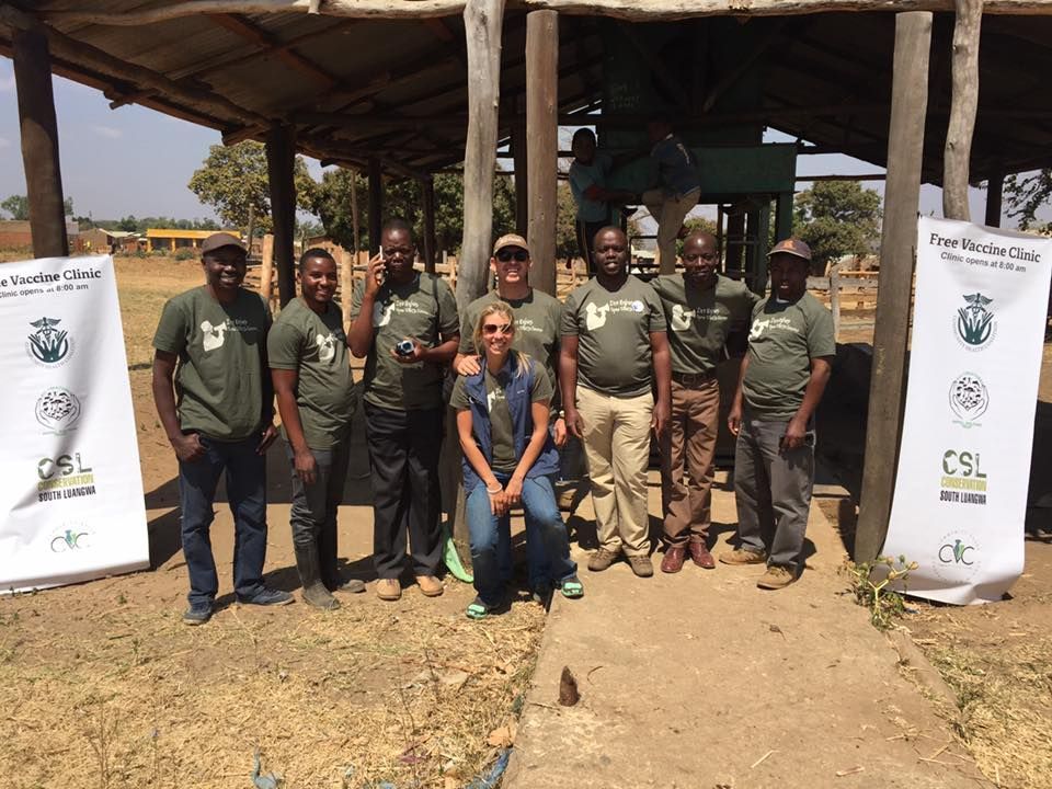 a group of people standing in front of a sign that says free vaccine clinic