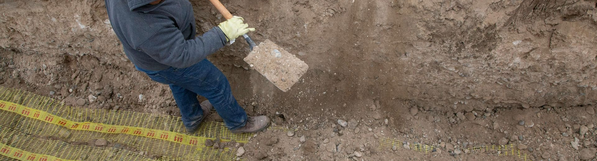 Backhoe digging up a sewer line in Montana