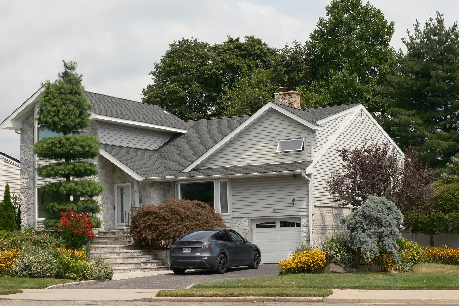 A car sits in the driveway of  a single family home