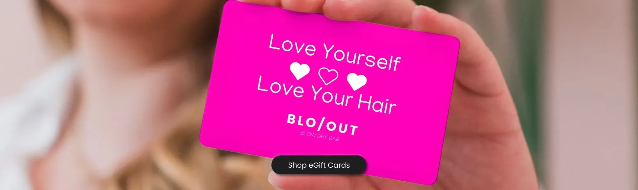 A woman is holding a pink card that says `` i love you self love your hair ''.