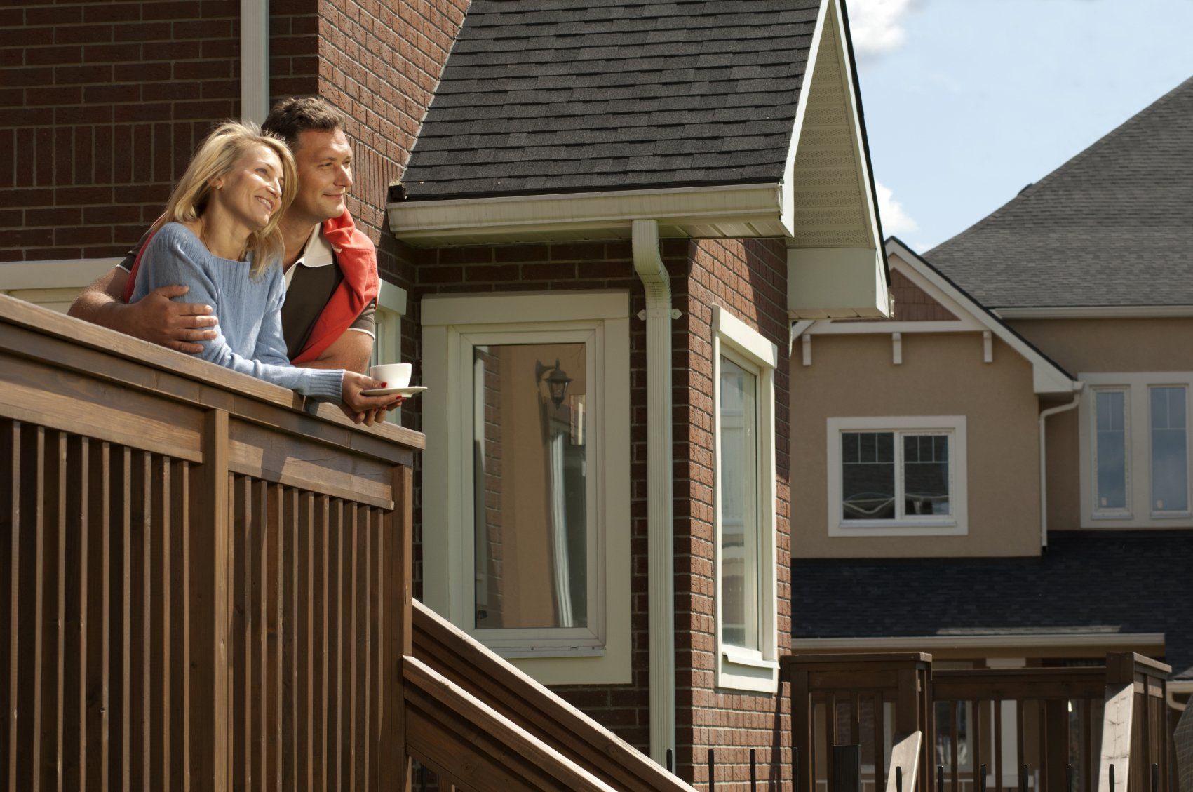 Young couple on front porch of their new suburban house