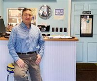 A man is standing in front of a counter in a store.