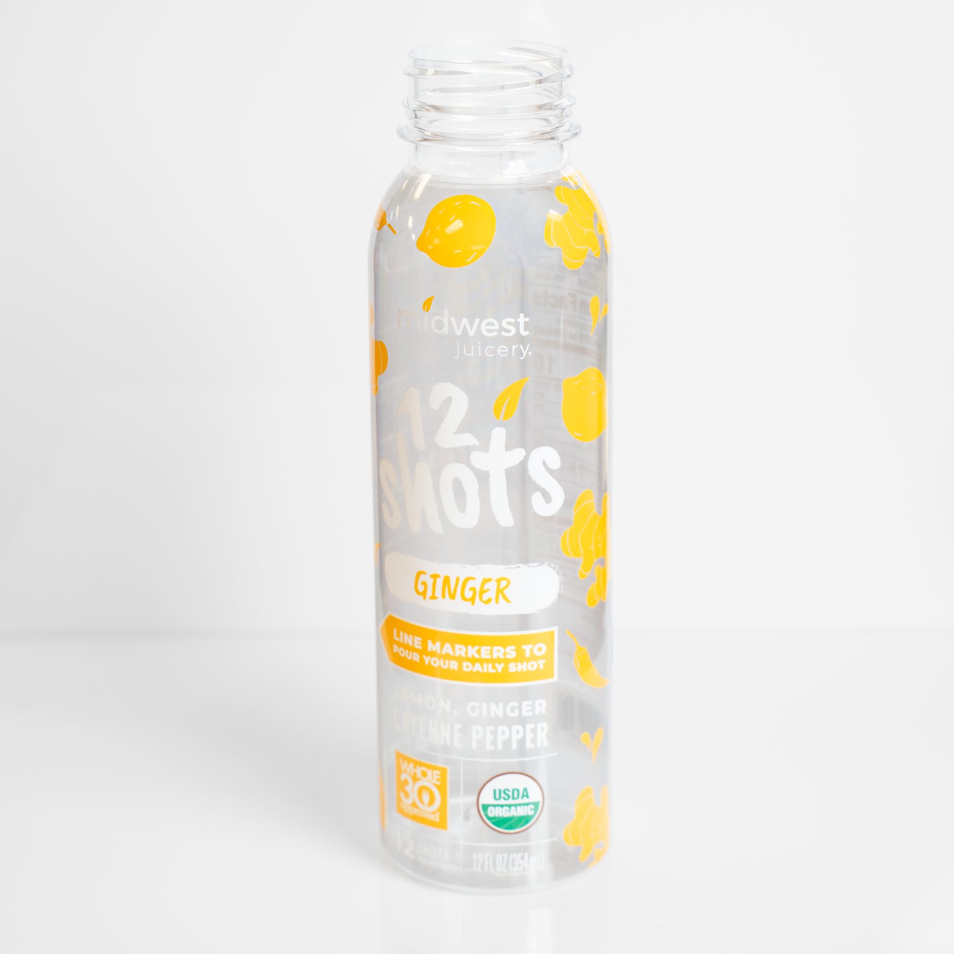 Clear glass bottle with yellow fruit graphics and white label on a white background