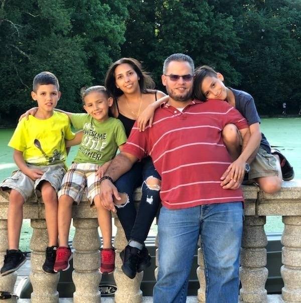 A group of people posing for a picture with one of them wearing a shirt that says awesome life