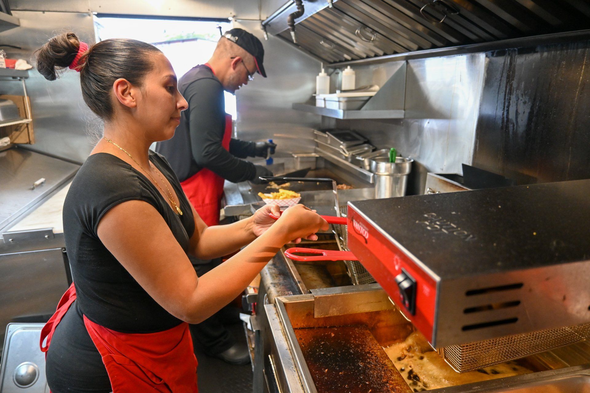 A man and a woman are preparing food in a kitchen.