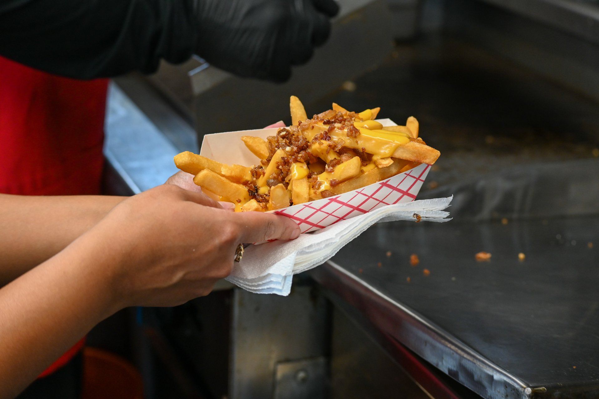 A person is holding a bag of french fries in their hand.