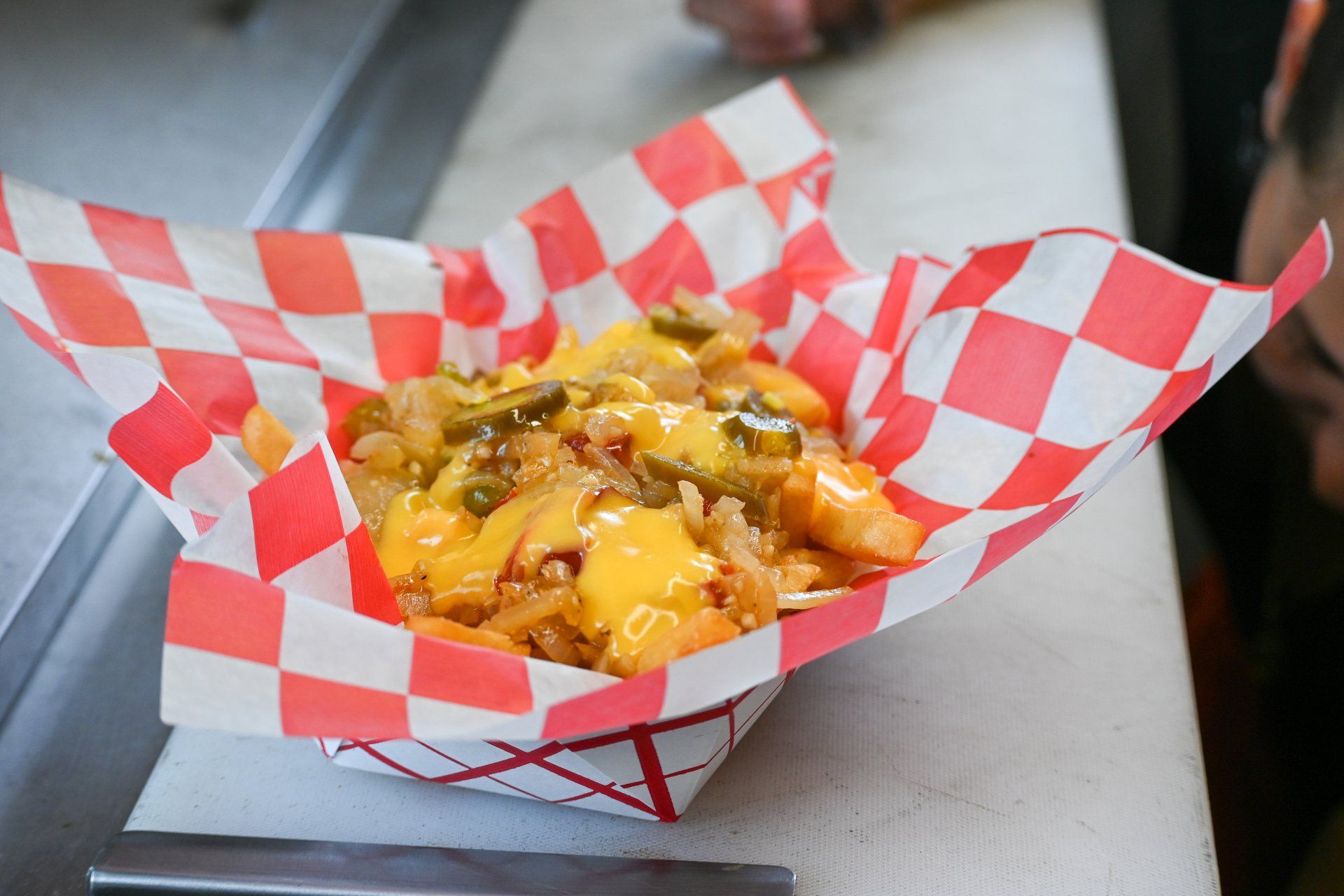 A tray of french fries wrapped in checkered paper