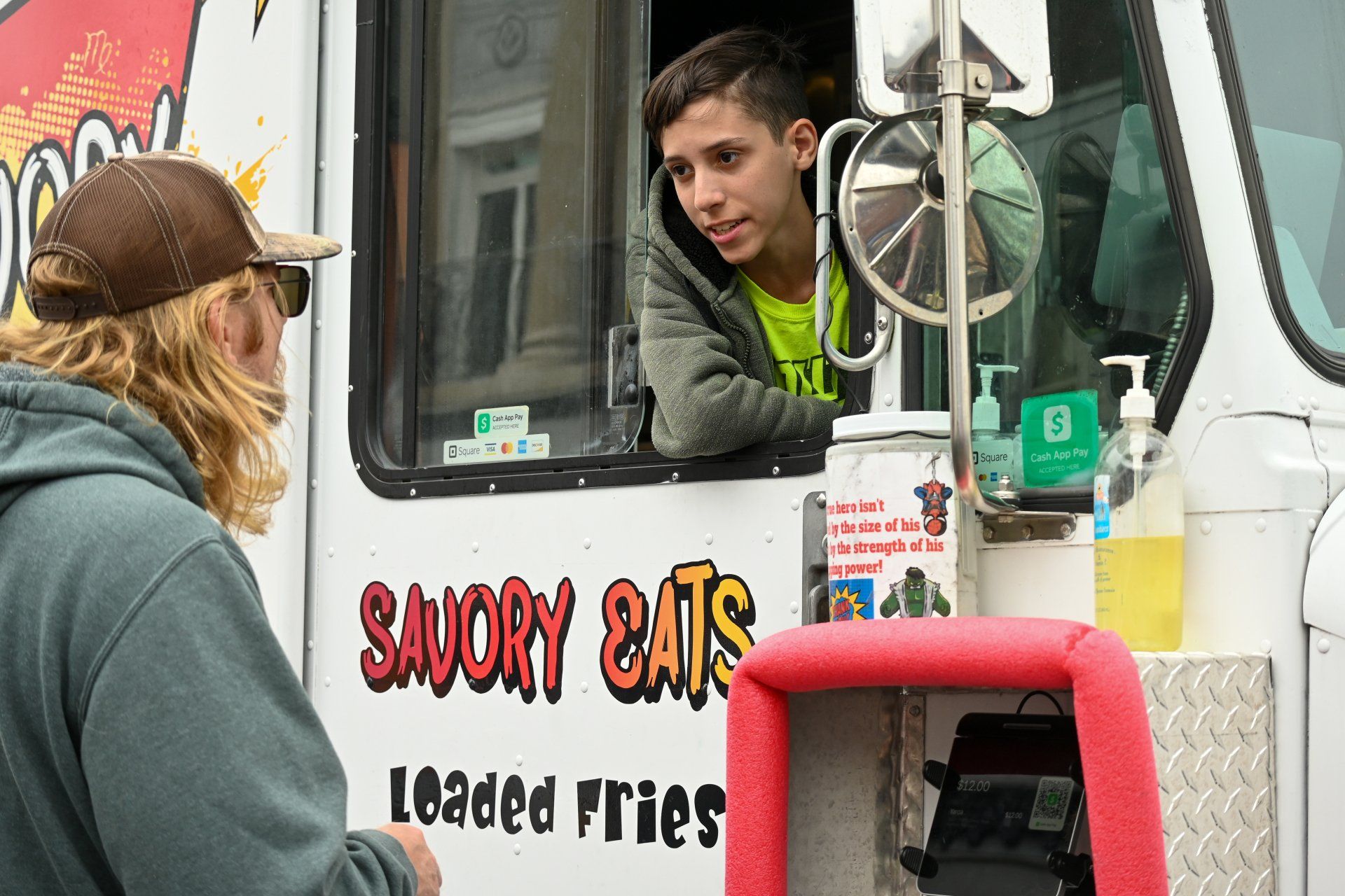 A man is talking to a man in a food truck.