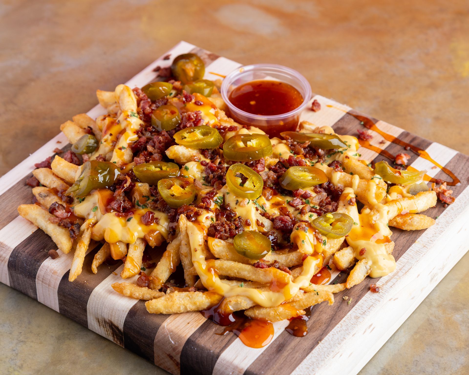 A person is holding a container of food in a red and white checkered paper.