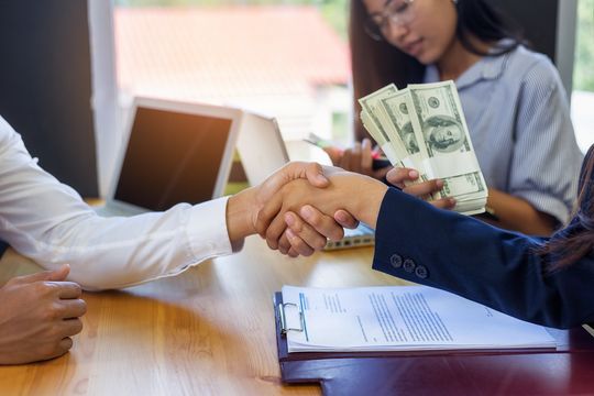 a woman holding a bundle of money