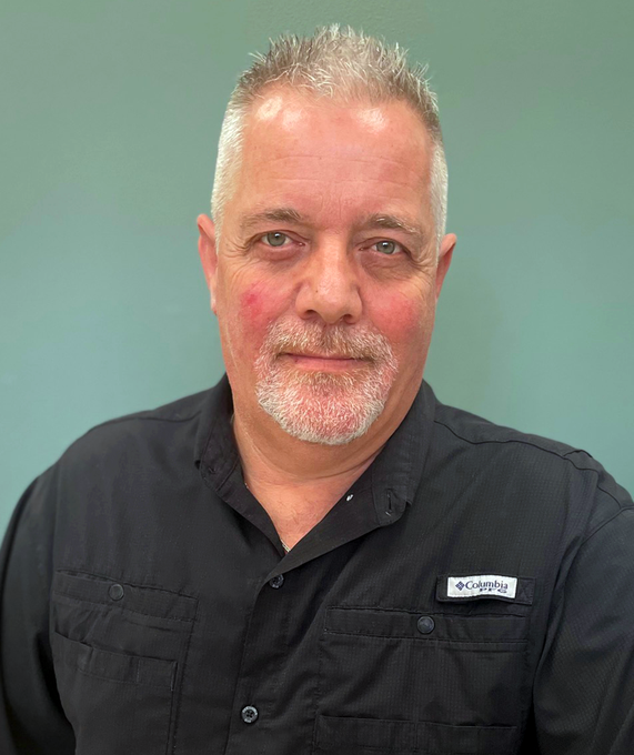 Man with graying hair and goatee, wearing a black shirt, looking at the camera.