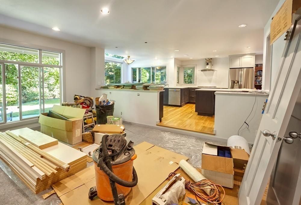 a kitchen is being remodeled with a refrigerator in the middle of the room .