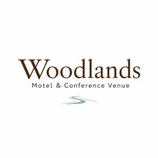Woodlands Motel & Conference Venue logo in brown and teal on a white background