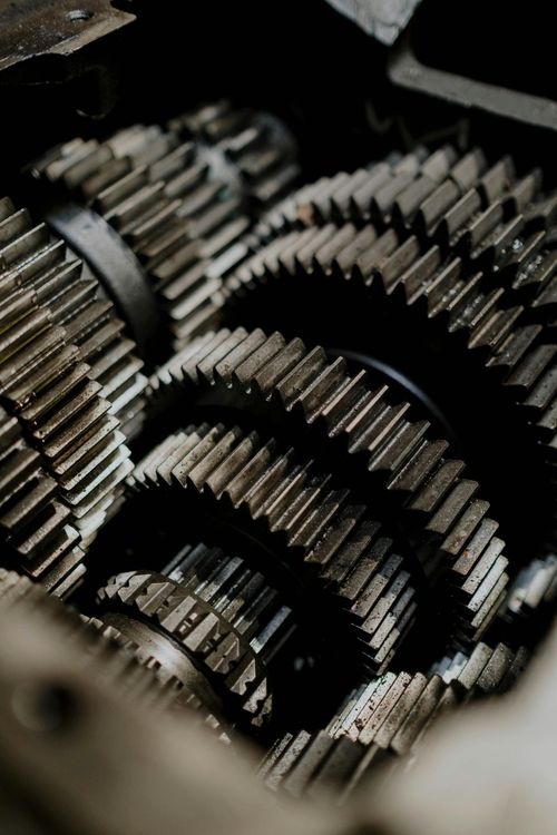 A close-up, high-angle view of multiple interlocking metal gear wheels inside a mechanical assembly.
